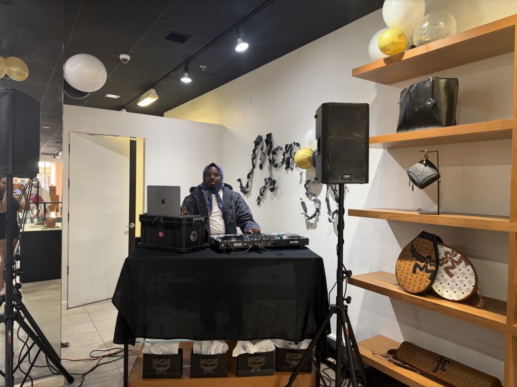 The DJ table inside the MCM Cabazon store with MCM bags on the shelves and gift bags under the table, March 28, 2026